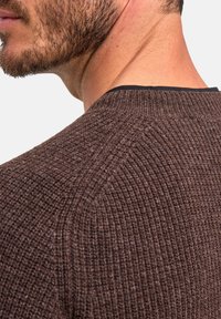 Maglione marrone con texture e motivo a costine, caratterizzato da un collo rotondo e un bordo a contrasto nero al colletto.