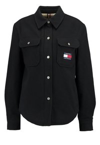 Czarna flanelowa koszula z guzikami z przodu, dwiema kieszeniami na piersi oraz małą naszywką z logo Tommy Jeans. Miękka tekstura i kołnierzyk.