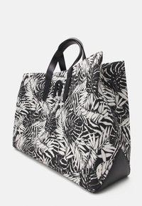 Velká taška s černobílým vzorem tropických listů na látce, s černými syntetickými koženými rukojeťmi a akcenty.