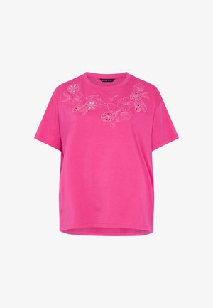 Pink kortærmet t-shirt med hvide broderede blomster- og frugtmønstre på tværs af brystet nær halsudskæringen.