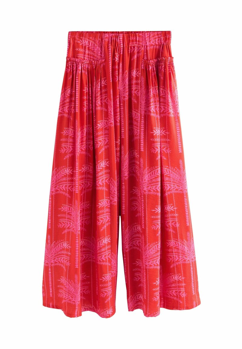 Pantalon large rouge avec imprimé palmiers roses et taille élastique, coupe ample et tissu léger.