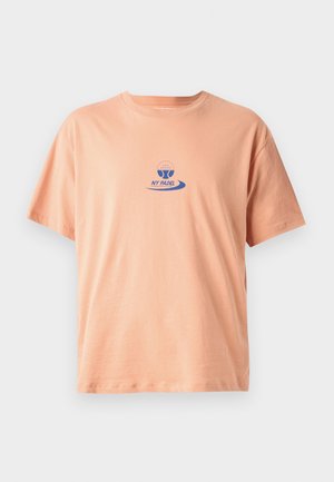 T-shirt en coton de couleur pêche avec des manches courtes, un col rond, et un logo imprimé bleu avec un design de pagaie et le texte "NY PADEL."