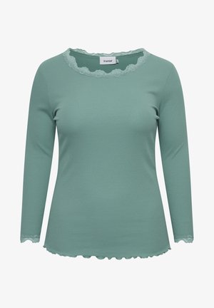 Mintgrøn langærmet top lavet af ribbet stof, med en bølget blondekant ved halsudskæringen og ærmekanterne, samt en afrundet bund