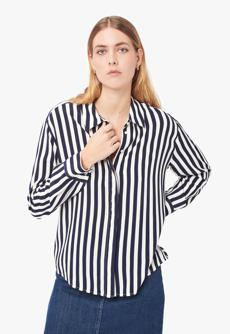 Camicia a righe blu navy e bianca con maniche lunghe, colletto, patta con bottoni e una vestibilità comoda. Tessuto morbido con una trama liscia.