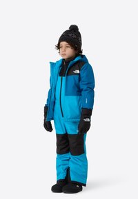 Bright blue insulated snowsuit with black accents, featuring a hood, gloves, and warm boots. Smooth texture, designed for cold weather.