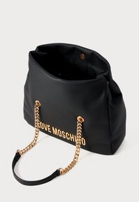 Black soft shoulder bag with gold chain straps and "LOVE MOSCHINO" gold lettering, open top showing interior lining and clasp.