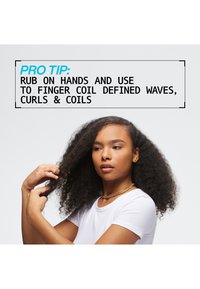 Het product toont een persoon met lang, krullend haar, gekleed in een wit T-shirt. Het haar is dicht en volumineus; de sieraden zijn een gouden ketting. 