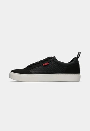 Zwarte sneaker met een textuur bovenkant, gekenmerkt door een logo patroon, platte veters en een witte rubberen zool, verfraaid met een rood merklabel.