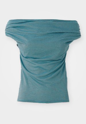 Peplum tops ar pleciem, zilo un melno horizontālu svītru dizainu. Viegls audums ar nelielu drapējumu, īsām piedurknēm un piegulošu siluetu.
