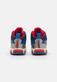 Siniset ja punaiset urheilukengät, joissa on teksturoitu hopeinen yksityiskohta. Korkea malli, verkkokangas ja pehmustettu kaulus mukavuutta varten.