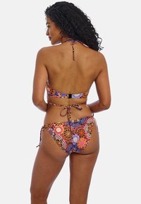 Kleurrijke bikini met een bloem- en geometrisch patroon. De top heeft een halternek en een haaksluiting op de rug; de broekjes hebben strikjes aan de zijkanten.