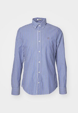 Camisa de botones con rayas verticales azul y blancas, un cuello puntiagudo y mangas largas con puños a rayas en contraste.