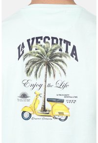 Camiseta azul claro con un diseño gráfico de una palmera y una scooter amarilla, con el texto "LA VESPRITA" y "Disfruta la Vida".
