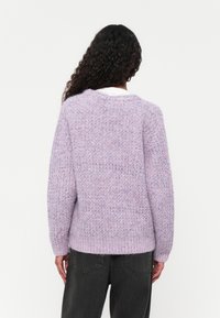 Lila gestrickter Pullover mit einem strukturierten Muster, geripptem Saum und langen Ärmeln. Fein detailliertes und weiches Material mit einer lockeren Passform.