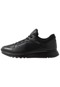 Czarne buty sportowe wykonane z skóry i siateczki, z okrągłym noskiem, sznurowanym zapięciem oraz teksturowaną podeszwą z rowkami zapewniającymi przyczepność.
