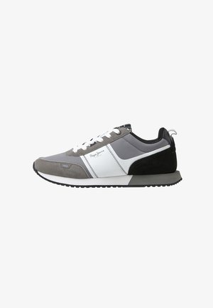 Graue und schwarze Sneakers mit weißen Akzenten. Mischung aus Leder und Wildleder, runde Zehenpartie, gepolsterter Kragen und kontrastierende Sohle.