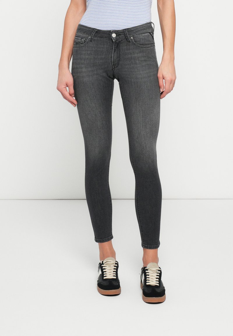 Dark gray skinny jeans made of denim, featuring a five-pocket design, slight fading, and a secure button closure at the waist.