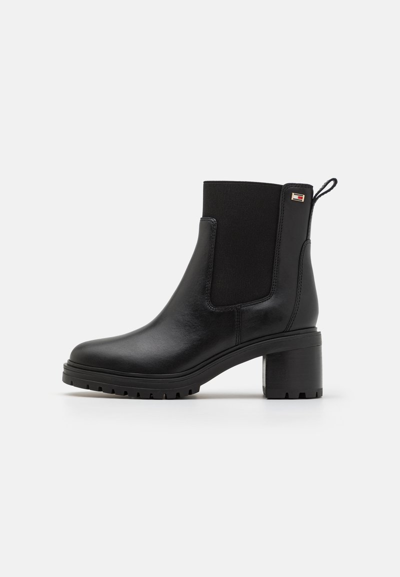 Sorte lær ankle boots med elastiske sidestykker, en chunky hæl og en tekstureret sål. Inkluderer en lille logoaccent på hælen.