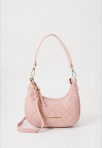 Mala rosa matelassê com formato curvo, ferragens douradas e alça destacável. Apresenta o logótipo "VALENTINO" na parte da frente.