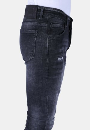 Zwarte denim jeans met een slim fit, voorzien van slijtplekken aan de voor- en achterkant, en een gestructureerd oppervlak. Inclusief een leren merkpatch op de taille.