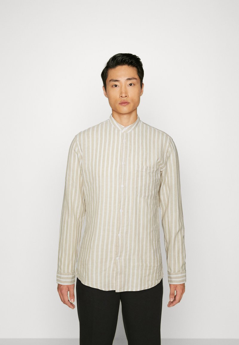 Camicia a maniche lunghe di colore chiaro, con sottili righe verticali, colletto alla cinese, taschino sul petto e una consistenza morbida.