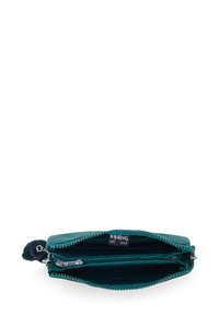De teal Kipling portemonnee heeft een gladde buitenkant, een ritsluiting, dubbele vakken en een harige ritsenkleur voor gemakkelijk gebruik.