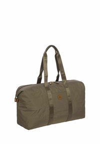 Sac de sport vert olive en nylon, doté de deux poignées de transport, d'une fermeture éclair et d'un patch logo à l'avant.