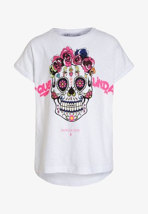 Weißes T-Shirt mit kurzen Ärmeln, das eine bunte Sugar-Skull-Grafik mit Blumen zeigt. Der Text lautet „Que Linda“ in Pink. Markenetikett sichtbar.