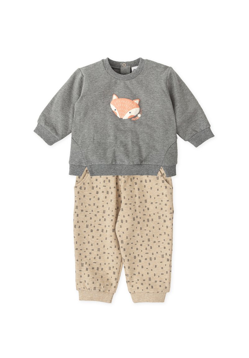 Sudadera gris con un gráfico de un zorro, combinada con pantalones beige de estampado que presentan pequeños cuadrados. Tejido suave, estilo casual.