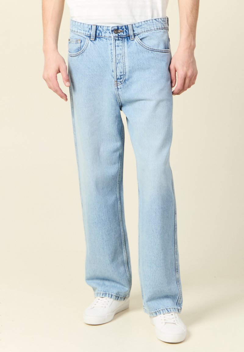 Ljusblå denimjeans med rak passform, femfickorsdesign och knappgylf. Tyget har en mjuk textur och subtila sömnadsdetaljer.