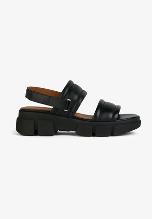 Sandales en cuir noir avec deux larges sangles, dotées d'une semelle plateforme épaisse avec des blocs rectangulaires et d'une sangle de talon ajustable.