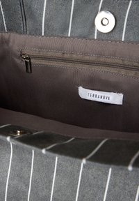 Szara torba materiałowa z białymi paskami, z zamykaną kieszenią wewnętrzną, metalowym zapięciem i metką z napisem "Terranova."