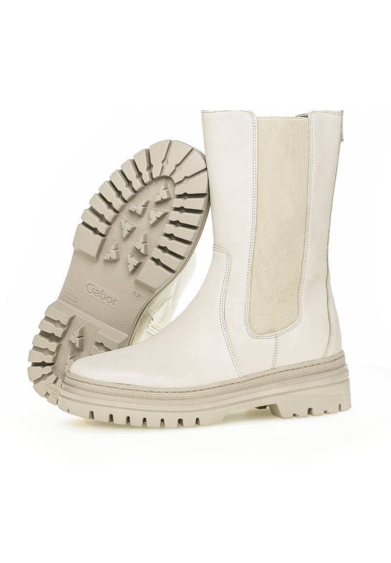 Witte leren enkellaarsjes met elastische zijpanelen, textuur rubberen zolen en een vlakke uitstraling. De zool heeft diepe groeven voor grip.