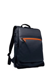 Sac à dos gris foncé en matériau lisse, avec une poche avant zippée orange et des bretelles ergonomiques. Design minimaliste.