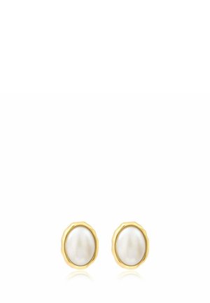 Boucles d’oreilles clous en perle blanche ovale, montées dans des montures métalliques dorées irrégulières sur fond blanc.
