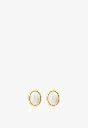 Boucles d’oreilles clous en perle blanche ovale, montées dans des montures métalliques dorées irrégulières sur fond blanc.