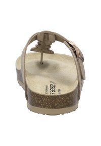 Sandal beige chiaro con cinturini in suede e una soletta in sughero. Presenta un dettaglio decorativo a forma di foglia e una fibbia metallica. Suola piatta con una leggera texture.