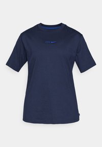 Marineblå bomullströja med rund hals, korta ärmar och "CFC"-logotyp i blått ovanför Nike-swooshen. Slät textur och avslappnad passform.