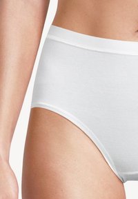 Weiße Baumwollunterwäsche mit glatter Textur, hoch tailliertem Design und elastischem Bund, die eine einfache, nahtlose Konstruktion zeigt.