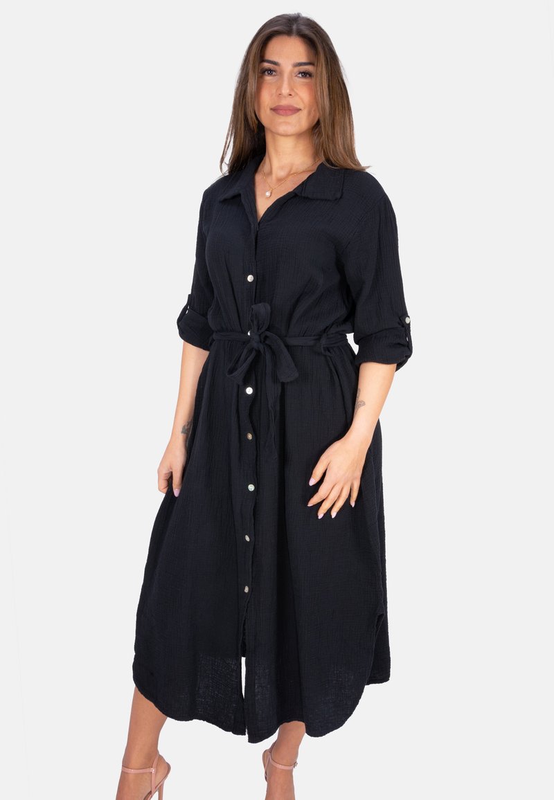 Robe noire à boutons, fabriquée en tissu texturé, dotée d'une ceinture à nouer, de manches longues et d'une coupe mi-longue avec une silhouette fluide.