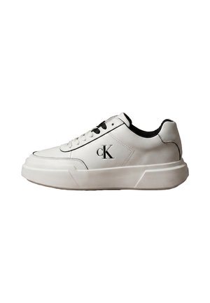 Baskets basses en cuir blanc avec semelle épaisse, lacets noirs et blancs et logo noir "cK" sur le côté.