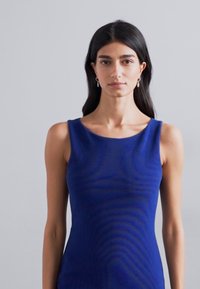 Abito aderente senza maniche in tessuto blu intenso con una leggera texture. Collo arrotondato, design minimale e finitura liscia.