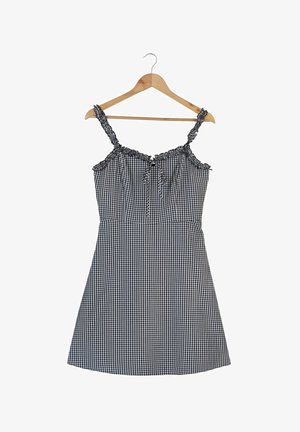 Sukienka w czarno-białą kratkę gingham z cienkimi ramiączkami, marszczonymi detalami na ramionach oraz dopasowaną talią przechodzącą w rozkloszowaną spódnicę.