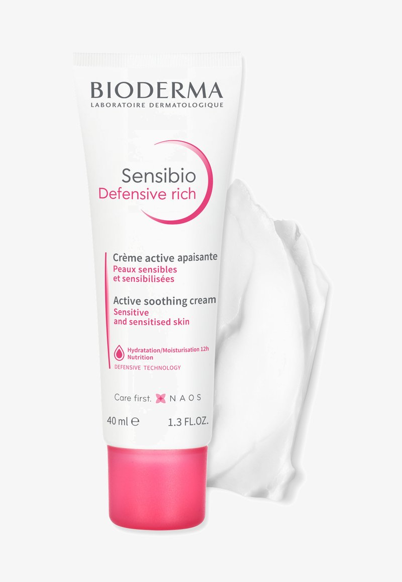 Crème riche Bioderma Sensibio Defensive dans un tube blanc avec une base rose. Présente des propriétés apaisantes actives ; 40 ml, texture lisse et crémeuse.
