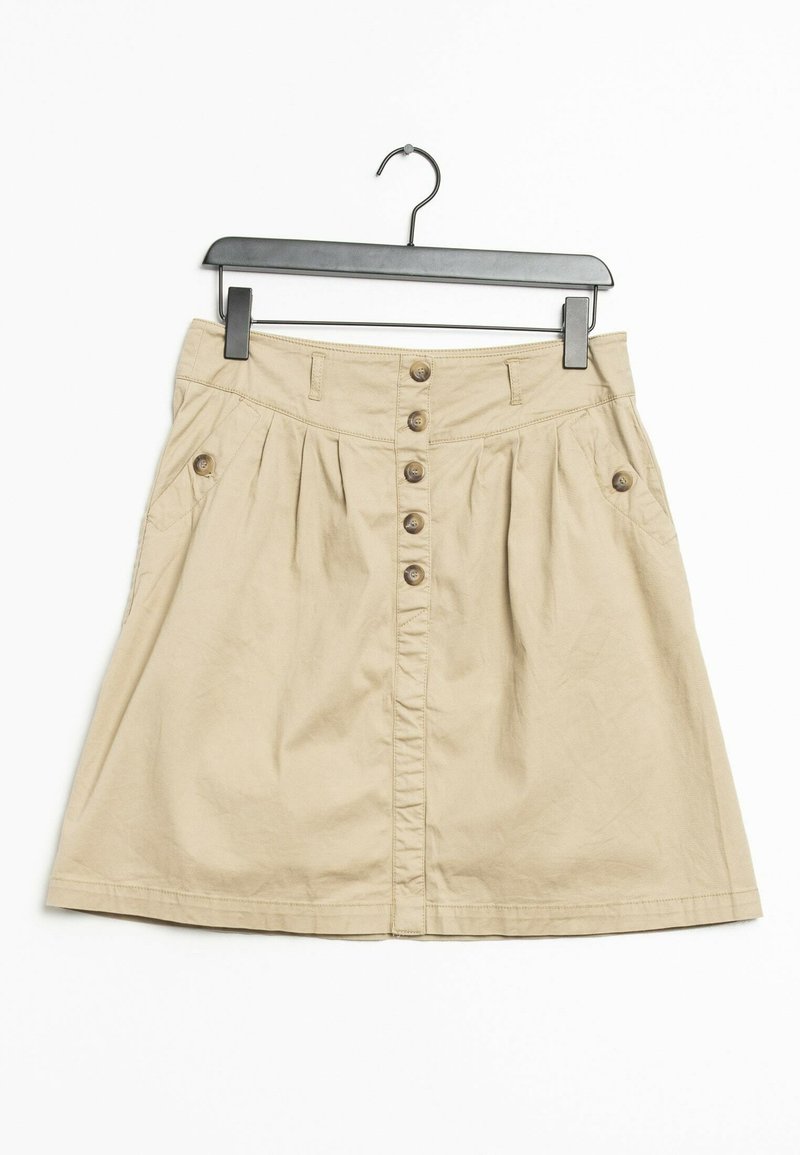 Khaki beige cotton skirt with a flared silhouette, featuring a button front closure, side pockets, and subtle pleats. Hangs on a black hook.