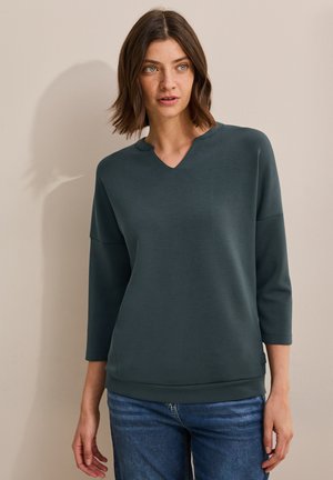 Dunkelgrüner Pullover mit V-Ausschnitt, Dreiviertelärmeln und lockerer Passform. Hergestellt aus glattem Stoff, mit geripptem Saum und Bündchen.
