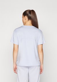 Ljusblå kortärmad t-shirt med rund halsringning och rak nederkant, med sidslitsar och en mjuk, len textur.