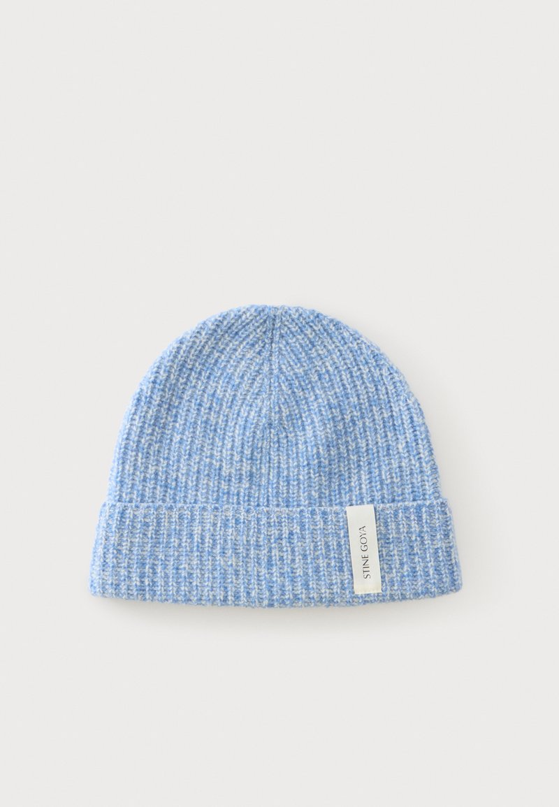 Bonnet tricoté bleu clair avec bord replié et étiquette blanche portant la mention "STINE GOYA" sur un fond uni clair.