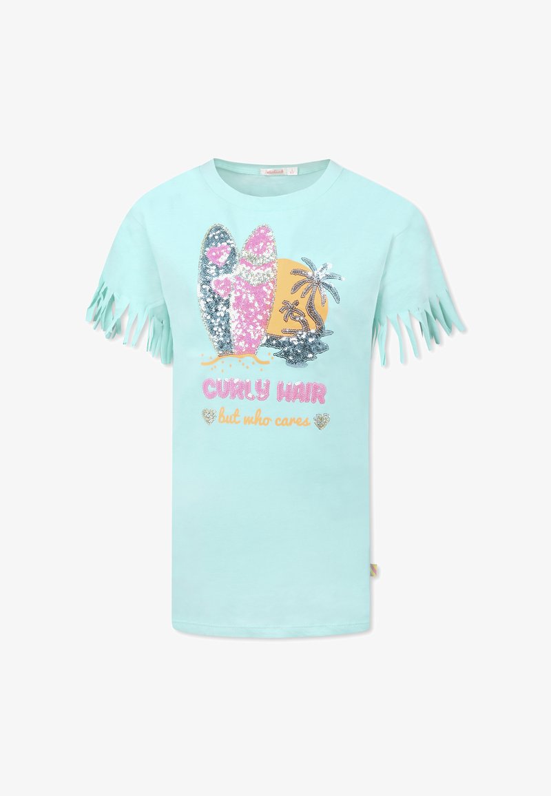 T-shirt turchese con maniche frangiate, con una grafica di tavole da surf e palme ricoperte di paillettes; il testo recita "Capelli ricci, ma chi se ne frega."