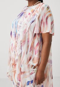 Przezroczysta, kolorowa sukienka o płynnej formie, z abstrakcyjnymi wzorami w odcieniach różu, pomarańczu i niebieskiego. Miękka, lekka tkanina.